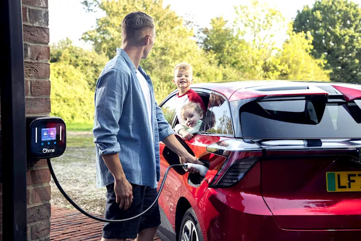 man and children charging electric car